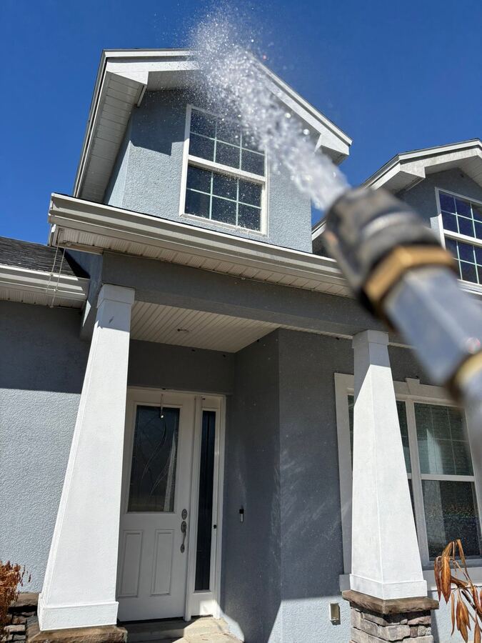 Soft washing a home exterior stucco and windows in Lakeland, FL